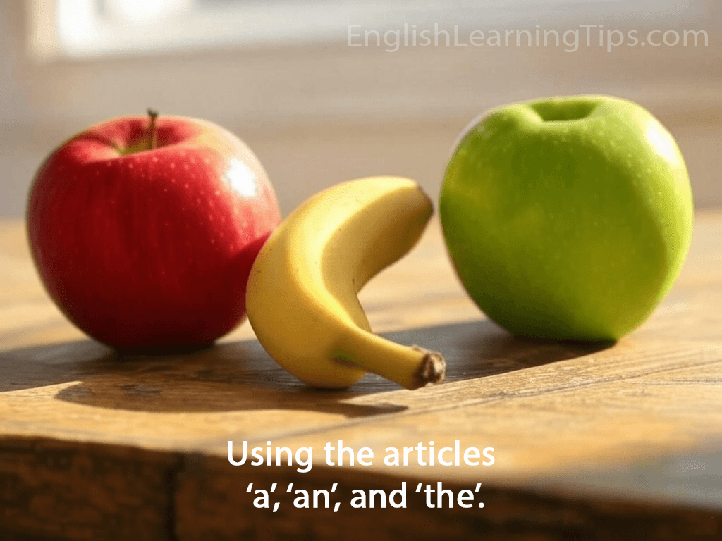 A banana and an apple on a table illustrating the use of English articles a and an.