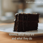 A slice of chocolate cake on a white plate representing the English idiom "a piece of cake"