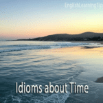 A peaceful beach at sunrise with the text "Idioms about Time" overlaid in the foreground.