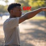 A young man pointing away from himself with the word "GO!" in red text, illustrating movement away from a speaker.