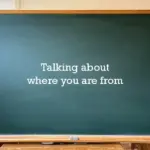 A green chalkboard in a classroom with the text "Talking about where you are from" written in the center.
