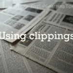A close-up, blurred view of several newspapers with the text "Using clippings" overlaid in a white serif font.