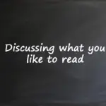 A chalkboard with the text "Discussing what you like to read" written on it for an English language lesson.