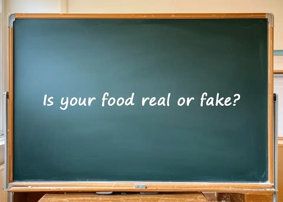 A classroom chalkboard with the text "Is your food real or fake?" written on it.